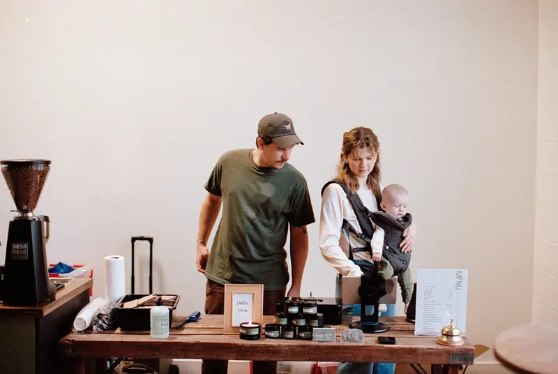 Kyle, Izzy, and Oliver behind the market table