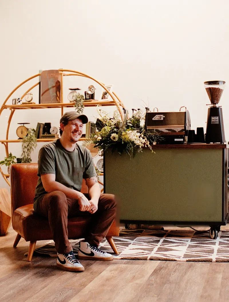 Kyle sitting in front of the cart he built, shot on film